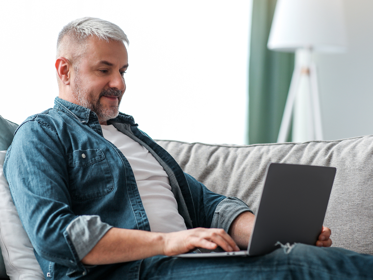 Propriétaire à distance consultant son ordinateur depuis son canapé